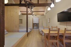 a room with a dining table and a bedroom at Bonju Abikomichi in Osaka