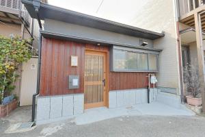 a house with a wooden door and a parking meter at Bonju Abikomichi in Osaka