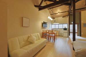 a living room with a couch and a dining room at Bonju Abikomichi in Osaka