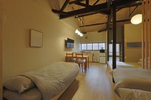 a room with two beds and a kitchen with a table at Bonju Abikomichi in Osaka