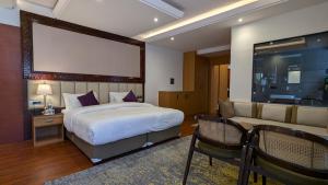 a hotel room with a bed and a couch at Hotel The Haven Kargil - Centrally Heated in Kargil +57 photos