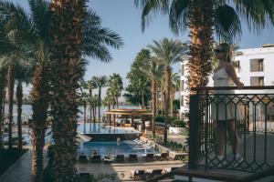 a woman standing on the balcony of a resort at Hilton Luxor Resort & Spa in Luxor