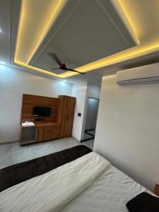 a bedroom with a bed and a flat screen tv at KD Palace Hotel And Restaurant in Jaipur