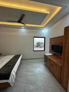 a bedroom with a bed and a flat screen tv at KD Palace Hotel And Restaurant in Jaipur