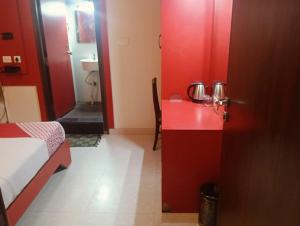 a red room with a bed and a red desk at Royal shades kodihali in Bangalore