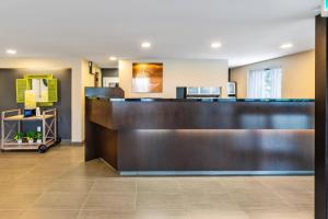 a hotel lobby with a large wooden reception desk at Comfort Inn Sudbury East in Sudbury