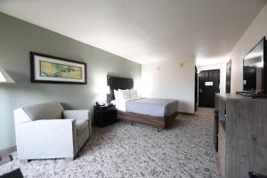a hotel room with a bed and a couch at Quality Inn & Suites Mattoon South in Mattoon