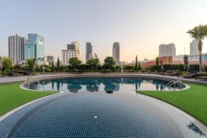 a swimming pool with a city skyline in the background at Happihaus Hotel Bangkok in Bangkok