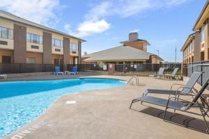 a swimming pool with lounge chairs in front of a building at Quality Suites Hickory South in Hickory