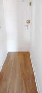 a white room with a wooden floor and a door at La bonne location à HOSSEGOR ! in Soorts-Hossegor