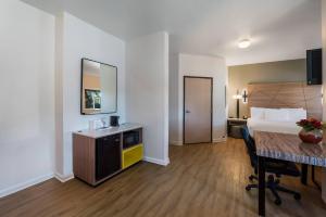 a hotel room with a bed and a desk and a table at Quality Inn Yuba City-Marysville in Yuba City