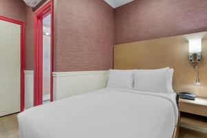 a bedroom with a white bed and a window at The Mayfair Hotel Times Square, an Ascend Collection in New York