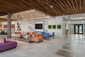 a lobby with couches and chairs and a flat screen tv at Hilton Garden Inn Perry in Perry
