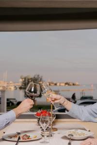 two people holding glasses of wine at a table at Hotel Niko in Zadar +79 photos