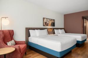 a hotel room with a bed and a chair at Hilton Garden Inn Perry in Perry +36 photos