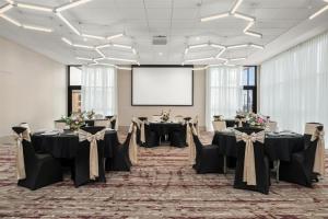 a conference room with tables and a projection screen at Hilton Garden Inn Perry in Perry