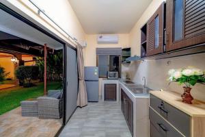 a kitchen with an open door to a patio at Taratai Villa Guest House in Nong Prue
