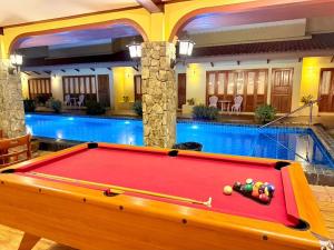 a pool table in front of a swimming pool at Taratai Villa Guest House in Nong Prue