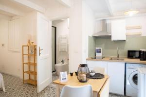 a small kitchen with a table and a sink at Petit Buragna in Alghero +15 photos
