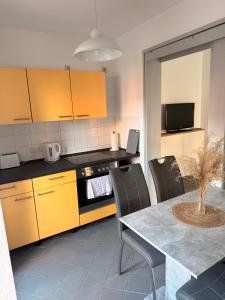 a kitchen with yellow cabinets and a table with chairs at Kleine-Auszeit am Dom Ferienwohnung für Gäste & Monteure in Halberstadt