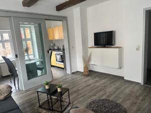 a living room with a couch and a tv on a wall at Kleine-Auszeit am Dom Ferienwohnung für Gäste & Monteure in Halberstadt