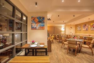 a dining room with tables and chairs in a restaurant at Udaan Olive Hotel & Spa, Pelling in Pelling