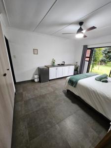 a bedroom with a bed and a large window at Little Oasis in Hilton