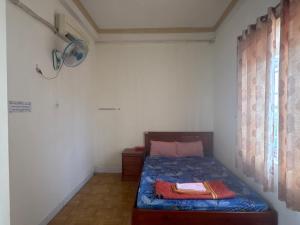 a small bedroom with a bed and a window at Hotel Minh Phát in Công Thanh