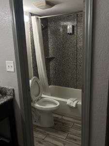a bathroom with a toilet and a tub and a shower at Western Inn Marietta in Atlanta +8 photos
