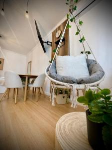 a room with a hanging chair and a table at VerdeViu Apartments 3 Thermalis Residence Sânmartin Oradea Băile Felix 1 in Sînmartin