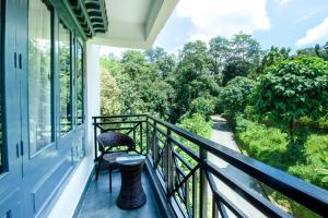 a balcony with two chairs and a view of a river at Udaan Olive Hotel & Spa, Pelling in Pelling