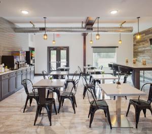 a restaurant with tables and chairs in a room at Iris Garden Inn in Savannah