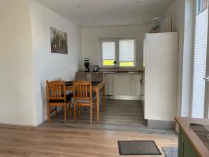 a kitchen and dining room with a table and chairs at Bei Kleins in Nümbrecht +5 photos