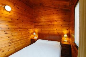 a bedroom with a bed in a wooden wall at Camping Ribamar in Alcossebre +26 photos