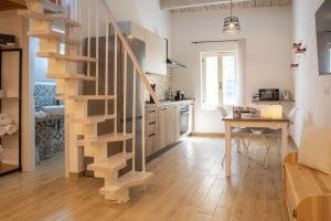 a kitchen with a wooden spiral staircase in a living room at Casa del Vicolo in Alghero