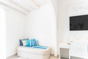 a white living room with a white couch and a tv at Luma Relais de Charme in Santa Teresa Gallura