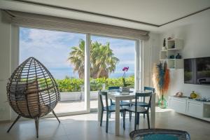 a dining room with a table and chairs and a large window at Maison Margot in Forio d'Ischia