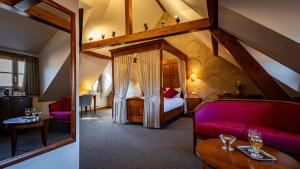a hotel room with a bed and a couch and a table at L'Abbaye d'Alspach in Kientzheim