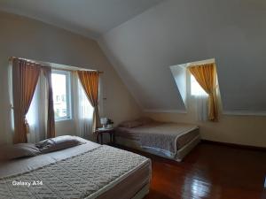 a bedroom with two beds and a window at Villa Dinar Mountain Estate in Lembang +46 photos