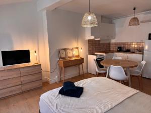 a room with a bed and a kitchen with a table at Studio climatisé in Narbonne
