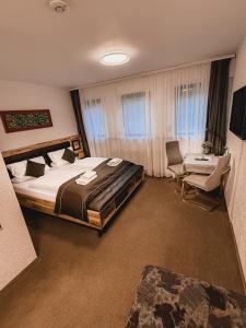 a bedroom with a large bed and a table and chairs at Hotel Kühns Mühle in Oestrich-Winkel