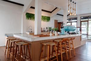 a kitchen with a island with bar stools at Girihill Farmhouse in Munduk