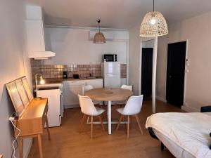 a small kitchen and dining room with a table and chairs at Studio climatisé in Narbonne