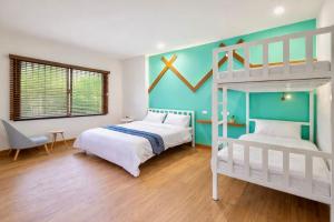 a bedroom with two bunk beds and a desk at BED Friends Poshtel in Chiang Rai