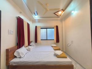 a large bed in a room with a window at HOTEL Shiv Sai in Shirdi