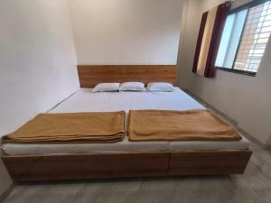 a large bed in a bedroom with at HOTEL Shiv Sai in Shirdi +2 photos