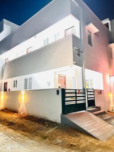 a white building with a gate in front of it at AAG Pride serviced apartments in Pollāchi
