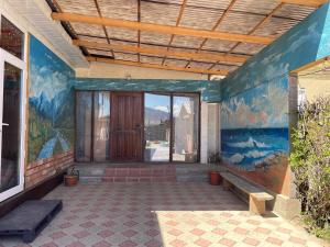 a room with a painting on the side of a building at Nukura in Bokonbayevo