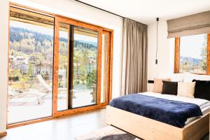 a bedroom with a bed and a large window at Wierzbowa16 in Szczyrk