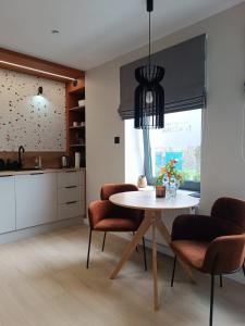 a kitchen and dining room with a table and chairs at Apartamenty Janasa 13 in Chorzów